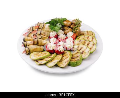 Frisch gegrilltes Gemüse, einschließlich Zucchini und Auberginen, begleitet Meeresfrüchte und Garnierungen auf einem großen weißen Teller und präsentiert ein lebendiges Sortiment an ava Stockfoto