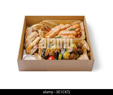 Diese Mahlzeit bietet perfekt gegrillte Lachsfilets, bunt geröstetes Gemüse und frisches Brot, serviert in einer praktischen Take-Out-Box, ideal Stockfoto