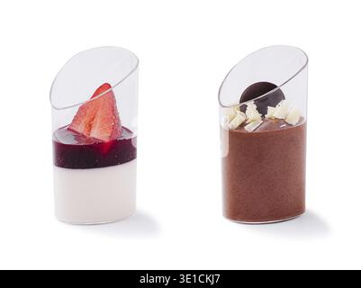 Zwei exquisite Desserts werden in eleganten Glasbechern bei einem geselligen Treffen serviert. Die eine enthält eine Erdbeere auf cremigen Schichten, während die andere r Stockfoto