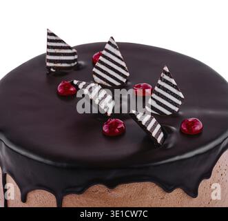 Schokoladenkuchen bedeckt mit Schokoladenglasur und verziert mit Schokoladendekorationen und roten Gelee-Bonbons ist isoliert auf weißem Hintergrund Stockfoto