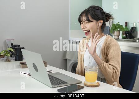 Glückliche junge asiatische Frau erfolgreiche Arbeit mit Laptop Überprüfung Glückliche Gratulation Erhalten Sie gute Nachrichten Junge asiaten fühlen sich begeistert und Kollege Student hat Exa bestanden Stockfoto
