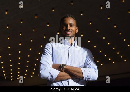 Low-Angle-Ansicht des schönen schwarzen afrikanischen Geschäftsmann im Freien in der Stadt während des Sommers lächelnd mit Armen gekreuzt horizontale Aufnahme Stockfoto