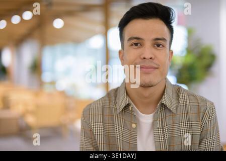 Porträt eines hübschen jungen Mannes, der im Café sitzt Stockfoto