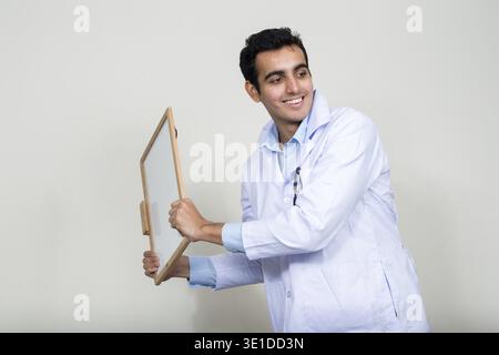 Studio shot der jungen schönen Indischen mann Arzt vor weißem Hintergrund Stockfoto