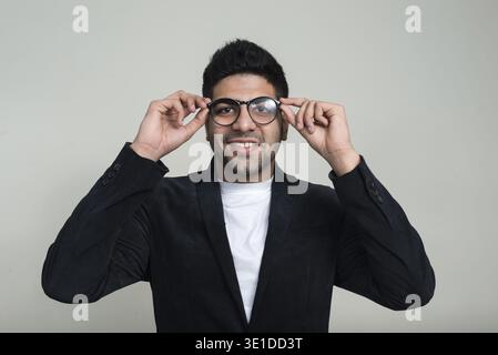 Studio-Aufnahme eines jungen gutaussehenden, bärtigen indischen Geschäftsmannes vor weißem Hintergrund Stockfoto