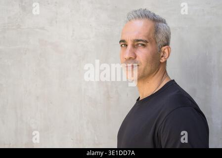 Porträt eines schönen persischen Mannes mit grauen Haaren gegen Beton Wand im Freien Stockfoto