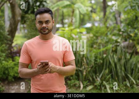 Porträt eines jungen, gutaussehenden bärtigen Indianers im Park Im Freien Stockfoto