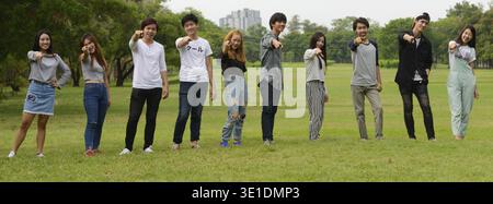 Eine Gruppe junger asiatischer Freunde, die sich im Park im Freien entspannen Stockfoto