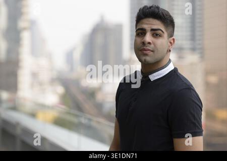 Porträt eines jungen, gutaussehenden Indianers gegen Blick auf die Stadt Stockfoto