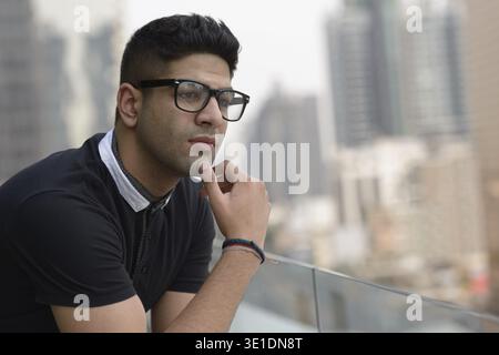 Porträt eines jungen, gutaussehenden Indianers gegen Blick auf die Stadt Stockfoto