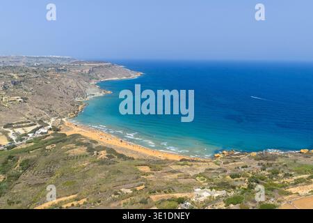 Erhöhter Blick auf die Ramla Bay in der Nähe von Nadur, Malta, mit einem breiten Sandsichel, felsigen Landzungen und klarem türkisfarbenem Mittelmeer-Wasser unter einem Sommer Stockfoto