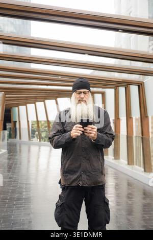 Porträt eines reiferen, gutaussehenden bärtigen Hipster-Mannes am Fußgängersteg in der Stadt Stockfoto