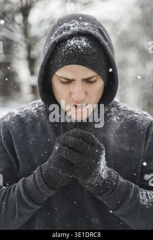 Porträt eines hübschen, athletischen Mannes, der während seines Wintertrainings draußen einen Hoodie trägt Stockfoto