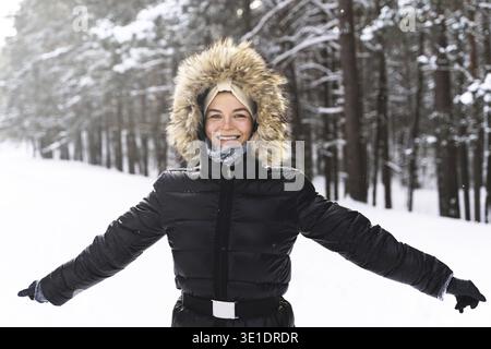 Porträt einer jungen und fröhlichen Frau, die während eines schönen Wintertages spazieren geht Stockfoto