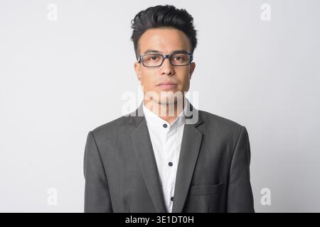 Studio-Aufnahme eines jungen asiatischen Geschäftsmannes im Anzug mit Brille vor weißem Hintergrund Stockfoto