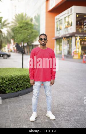 Porträt eines jungen gutaussehenden afrikanischen bärtigen Mannes mit Afro-Haaren, der die Straßen der Stadt im Freien erforscht Stockfoto