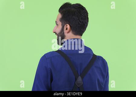 Studio-Aufnahme eines jungen gutaussehenden, bärtigen persischen Geschäftsmannes vor grünem Hintergrund Stockfoto