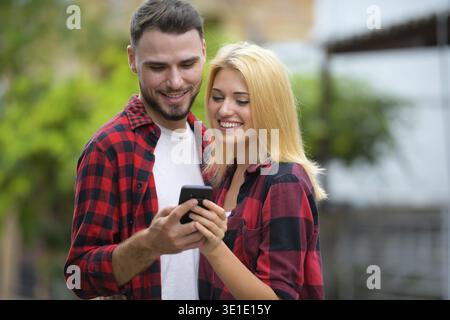 Porträt eines jungen gutaussehenden bärtigen Mannes und einer jungen schönen blonden Frau, die draußen auf der Straße sind Stockfoto