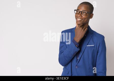 Studio shot von jungen Hübschen kahlen Afrikanischen Geschäftsmann in Anzug mit Brille vor weißem Hintergrund Stockfoto