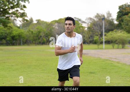 Porträt der jungen Hübschen Hispanic Mann im Park im Freien Stockfoto