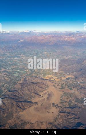 Eine Luftaufnahme zeigt eine Landschaft mit Bergen, Feldern und einem trockenen Seebad, was die Vielfalt des Geländes und der Landnutzung in der Region veranschaulicht. Stockfoto