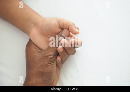 Hände von Erwachsenen und Kindern halten sich in einfacher Geste Stockfoto