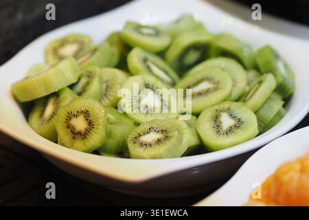 Geschnittene Kiwi auf einem weißen Teller zum Servieren Stockfoto