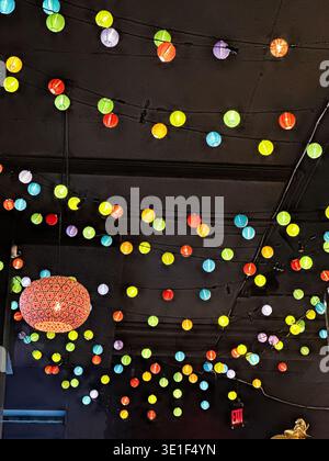 Mehrfarbige Lichter und ein Kronleuchter als Discoball beleuchten eine Party in einem Ballsaal. Stockfoto