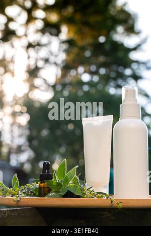 Weiße handgemachte Kosmetikflaschen Vorlage Mockup Hautpflege Kräuter Alternative Insektenschutz draußen im Sommer. Versuche, Mücken und Fliegen mit organischen Inhaltsstoffen Minzextraktöl zu töten. Prophylaxe-Desinfektion gegen Mückenstich an sonnigen Tagen. Stockfoto
