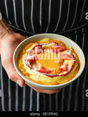 Der Konditor Präsentiert Cremiges Dessert Garniert Mit Erdbeeren Und Puderzucker In Gemütlichem Ambiente Stockfoto