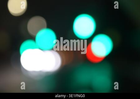 Schöner bewölkter Hintergrund der Nachtstraße mit seitlich verstreuten Ampeln der Nachtstadt. Hochwertige Fotos Stockfoto
