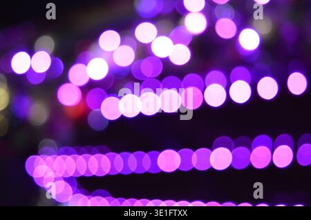 Wunderschöner dunkler Hintergrund mit lila Bokeh in einer Reihe. Hochwertige Fotos Stockfoto