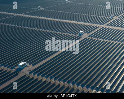 Aus der Vogelperspektive auf den riesigen Solarpark, der sich über die trockene Landschaft erstreckt und unter der Sonne glänzt, ein Beweis für erneuerbare Energien, Searchlight, Nevada, Stockfoto