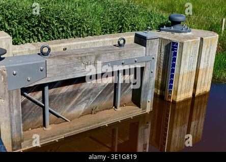 Rabbinge, Niederlande - 30. Mai 2021: Eine Wasserbewirtschaftungsstruktur mit Schleusentor und Wasserstandsanzeige ist im ländlichen Rabbinge Netherlands u zu sehen Stockfoto