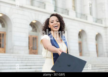 Aufgeregt, Berkeley-Absolvent wirft die Kappe zur Kamera Stockfoto