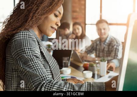 Fröhliche Geschäftsfrau, die der Gruppe eine Präsentation gibt Stockfoto