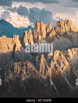 Blick auf das goldene Sonnenlicht, das die zerklüfteten Gipfel der Dolomiten küsst und lange Schatten über das felsige Gelände in Cortina d'Ampezzo, Venetien, Italien wirft. Stockfoto
