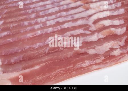 Rohe Speckscheiben, perfekt für Rezepte und Bilder. Frische, rohe Speckstücke mit ungekochter Fleischstruktur, ideal für Präsentationen und Rezeptbackings Stockfoto