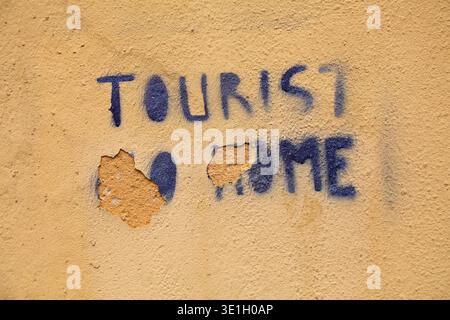 Tourist Go Home - eine schablonierte Nachricht in einer Straße in Catania, Italien. Anwohner gegen Massentourismus Belastung der Gemeinde. Stockfoto
