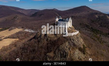 Schloss Füzér thront dramatisch auf vulkanischem Felsen über dem Dorf Füzér im Zemplén-Gebirge im Nordosten Ungarns – Luftaufnahme, März 2022 Stockfoto