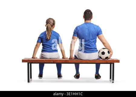 Rückansicht eines Mädchens und eines Fußballspielers, der auf einer Bank sitzt, isoliert auf weißem Hintergrund Stockfoto