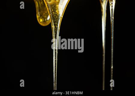 Fließender goldener Honig mit Luftbläschen Stockfoto