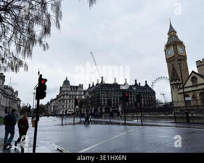 London, Großbritannien - 01. Februar 2026: Regnerischer, bedeckter Blick auf Big Ben, das London Eye und die Fußgänger, die in der Nähe von Regierungsgebäuden von Westminster kreuzen. Stockfoto