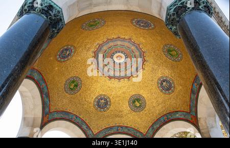 Atemberaubender architektonischer Blick auf eine islamische Kuppel mit komplexen goldenen Mosaiken mit runden Medaillons und arabischer Kalligraphie. Verzierte blaue Farbe Stockfoto