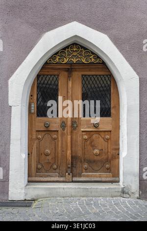 Massive Holztür, Bogentür mit dekorativen Metallverzierungen im Oberlicht in der historischen Altstadt von Konstanz, traditionelle Handwerkskunst Stockfoto