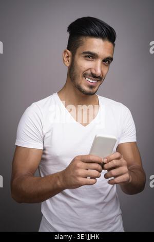 Studio shot der jungen schönen persischen Mann gegen grauer Hintergrund Stockfoto