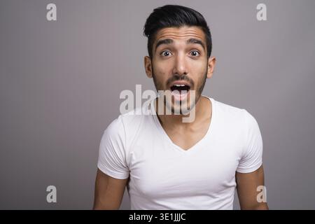 Studio shot der jungen schönen persischen Mann gegen grauer Hintergrund Stockfoto