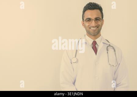 Studio shot der jungen schönen Indischen mann Arzt vor weißem Hintergrund Stockfoto