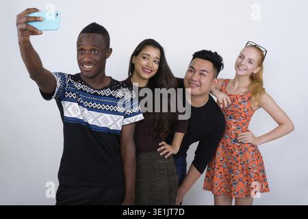 Studio shot von Happy vielfältige Gruppe von multi-ethnische Freunde und lehnte sich lächelnd auf die Schulter während der Einnahme von selfie Bild mit Handy zusammen Stockfoto