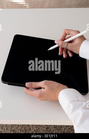 Weißes Hemd mit weiblichen Händen – Zeichnung auf Tablet mit Stift – Creative Tech Concept Stockfoto